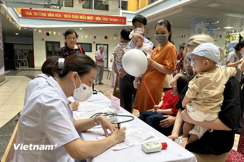 Nhân viên y tế khám, theo dõi sức khỏe cho trẻ em. (Ảnh: Thùy Giang/Vietnam+)