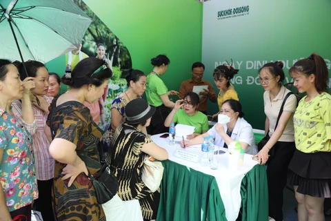 Các gian hàng với đông khách tham quan tại tuyến phố đi bộ được các chuyên gia về dinh dưỡng tư vấn sức khỏe.(Ảnh: PV/Vietnam+)