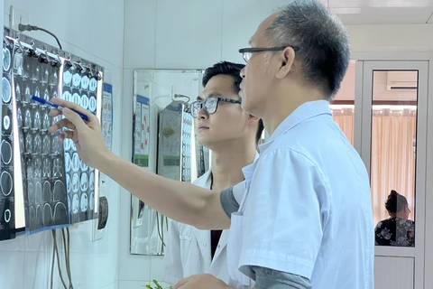Các bác sỹ Khoa Phẫu thuật Hàm mặt Tạo hình và Thẩm mỹ xem phim X-quang điều trị cho bệnh nhân. (Ảnh: PV/Vietnam+)
