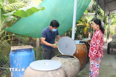 Nhân viên y tế giám sát mật độ lăng quăng, muỗi và tuyên truyền các biện pháp phòng, chống sốt xuất huyết cho hộ dân tại tỉnh Vĩnh Long. (Ảnh: Lê Thúy Hằng/TTXVN)