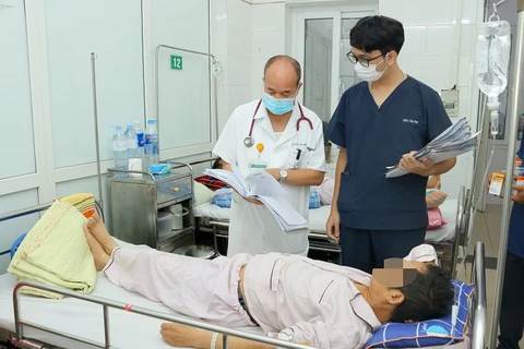 Phó giáo sư Đỗ Duy Cường thăm khám cho bệnh nhân. (Ảnh: PV/Vietnam+)