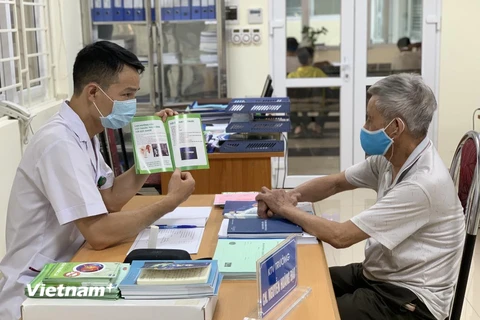 Nhân viên y tế tư vấn khám chữa bệnh cho người dân. (Ảnh: PV/Vietnam+)