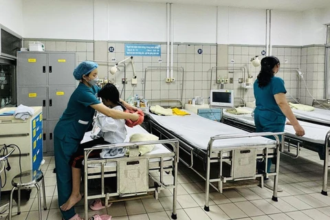 Nhân viên y tế chăm sóc sức khỏe cho bệnh nhân vụ cháy chung cư đang điều trị tại Bệnh viện Bạch Mai. (Ảnh: PV/Vietnam+)