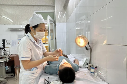 Một trẻ đau mắt đỏ phải bóc giả mạc tại Bệnh viện Mắt Trung ương. (Ảnh: T.G/Vietnam+)