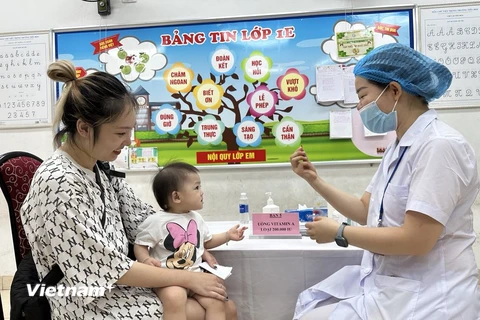 Cho trẻ uống bổ sung vitamin A tại Hà Nội. (Ảnh: T.G/Vietnam+)
