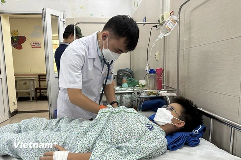 Bác sỹ Bệnh viện Xanh Pôn khám, theo dõi sức khỏe cho một bệnh nhi mắc bệnh truyền nhiễm. (Ảnh: T.G/Vietnam+)