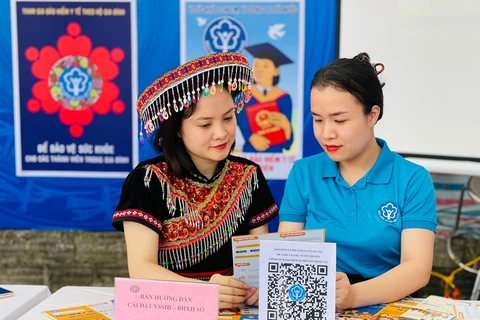 Nhân viên Bảo hiểm Xã hội Việt Nam tuyên truyền cho người dân về các chế độ chính sách. (Ảnh: PV/Vietnam+)