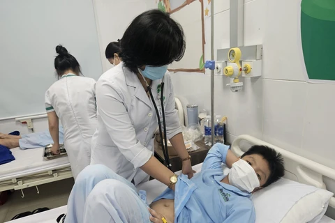 Bác sĩ Bệnh viện Đa khoa Sài Gòn-Nha Trang thăm khám cho bệnh nhi nghi do ăn thức ăn ở quán cơm gà ở Nha Trang, tỉnh Khánh Hòa. (Ảnh: TTXVN phát) 