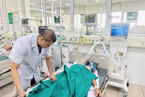 Bác sĩ Bệnh viện Bệnh Nhiệt đới Trung ương theo dõi sức khoẻ cho một trường hợp mắc bệnh dại trong tình trạng nặng. (Ảnh: PV/Vietnam+)