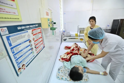 Bác sĩ theo dõi sức khỏe cho bệnh nhân mắc sốt xuất huyết tại Hà Nội. (Ảnh: Minh Quyết/TTXVN)