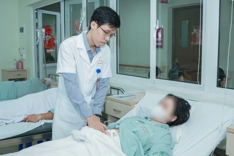 Bác sĩ thăm khám cho bệnh nhân sau phẫu thuật. (Ảnh: PV/Vietnam+)
