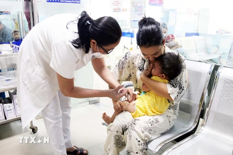 Nhân viên y tế tiêm vaccine phòng bệnh cho trẻ. (Ảnh: TTXVN/Vietnam+)