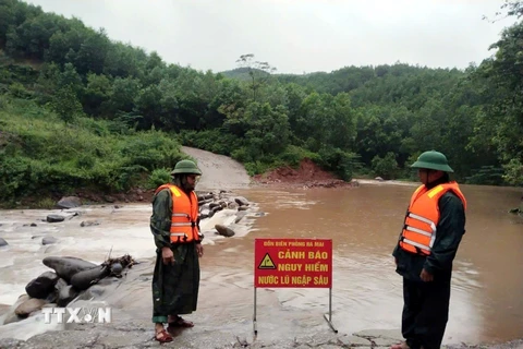 Lực lượng Đồn Biên phòng Ra Mai (huyện Minh Hóa, Quảng Bình) chốt chặn không cho người dân qua các ngầm tràn khi nước lũ dâng cao. (Ảnh: TTXVN phát)