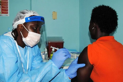 Nhân viên y tế tiêm vắcxin Ebola cho một phụ nữ Monrovia. (Nguồn: Reuters)