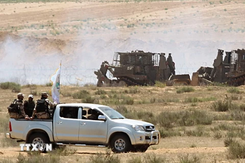Các thành viên Lữ đoàn Ezzedine al-Qassam, một cánh vũ trang của phong trào Hamas, tuần tại khu vực biên giới giữa Dải Gaza và Israel. (Nguồn: AFP/TTXVN)