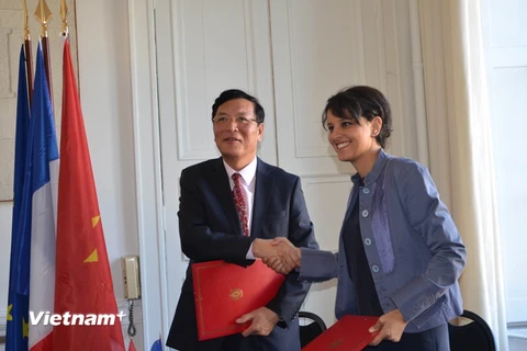 Bộ trưởng Phạm Vũ Luận và bà Najat Vallaud Belkacem trao đổi thỏa thuận hợp tác. (Ảnh: Tiến Nhất-Việt Sơn/Vietnam+)