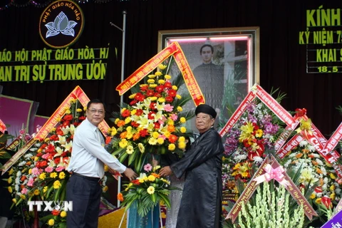 Phó Chủ tịch tỉnh An Giang Võ Anh Kiệt (áo trắng) tặng hoa chúc mừng đại diện Ban Trị sự Trung ương Giáo hội Phật giáo Hòa Hảo nhân kỷ niệm 75 năm Ngày khai sáng đạo Phật giáo Hòa Hảo. (Ảnh: Công Mạo/TTXVN)