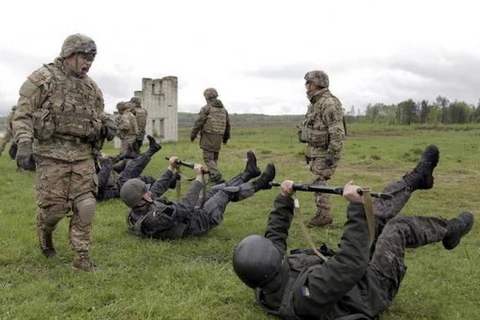 Sỹ quan Lữ đoàn Không vận 173 của Mỹ (đứng) huấn luyện các binh sỹ thuộc đơn vị Vệ binh Quốc gia Ukraine trong một cuộc tập trận chung. (Nguồn: Reuters)