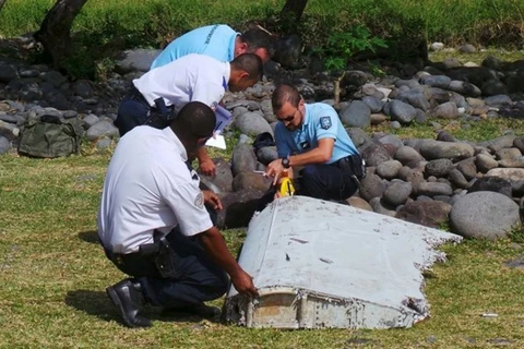 Nhân viên điều tra nghiên cứu mảnh vỡ máy bay tìm thấy. (Nguồn: AFP/Getty Images)