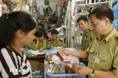 Lực lượng chức năng kiểm tra một cửa hàng kinh doanh mỹ phẩm. (Ảnh: Trần Việt/TTXVN)