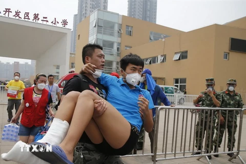  Sơ tán các nạn nhân khỏi khu vực nguy hiểm sau vụ nổ ở Thiên Tân. (Nguồn: THX/TTXVN)