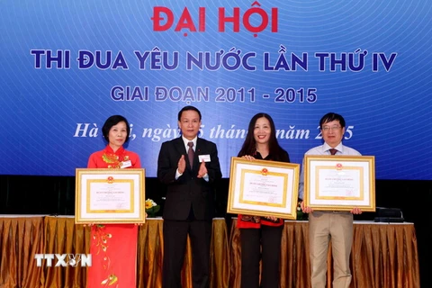 Tổng Giám đốc TTXVN Nguyễn Đức Lợi trao Huân chương Lao động Hạng Ba của Chủ tịch nước cho các cá nhân đã có thành tích xuất sắc trong quá trình công tác. (Ảnh: Quý Trung/TTXVN)