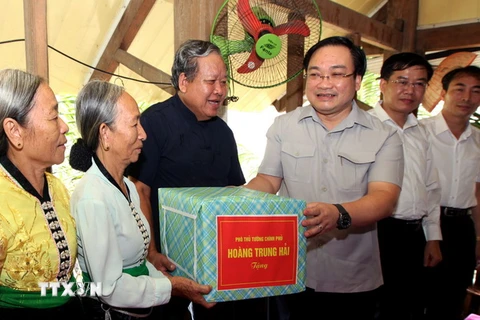 Phó Thủ tướng Hoàng Trung Hải đi kiểm tra, tặng quà một hộ dân tái định cư phường Na Lay, thị xã Mường Lay. (Ảnh: Ngọc Hà/TTXVN)