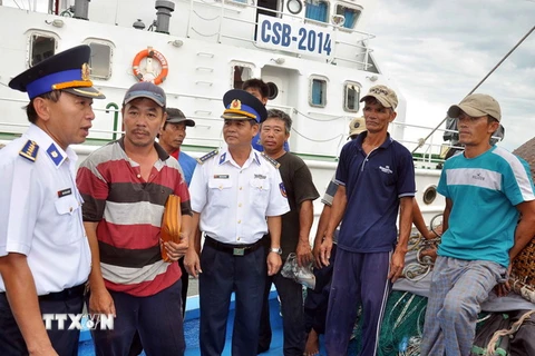Lãnh đạo Bộ Tư lệnh Vùng Cảnh sát biển 2 hỏi thăm các ngư dân trên tàu cá QNg 98001TS. (Ảnh: Đỗ Trưởng/TTXVN)