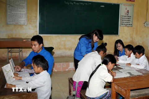 Sinh viên tình nguyện hướng dẫn ôn học Hè cho các em học sinh trường Dân tộc nội trú Trung Lèng Hồ. (Ảnh: Phạm Kiên/TTXVN)