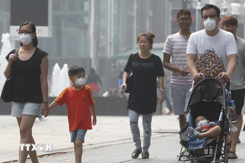 Người dân Singapore đeo khẩu trang để đối phó với tình trạng ô nhiễm khói bụi. (Nguồn: Reuters/TTXVN)