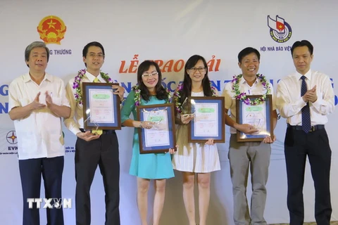 Nguyên Phó Chủ tịch thường trực Hội Nhà báo Việt Nam Hà Minh Huệ trao giải cho các tác giả đạt giải A. (Ảnh: Văn Sơn/TTXVN)
