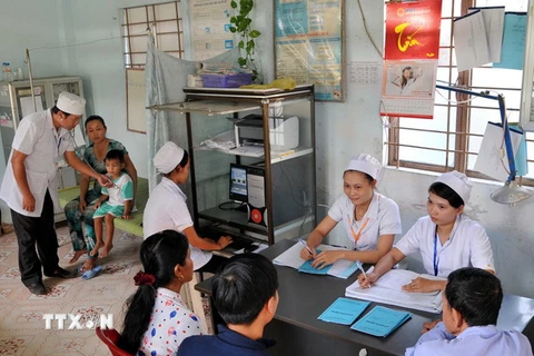 Khám chữa bệnh cho trẻ em tại trạm y tế xã Phú Tân, huyện Châu Thành, thành phố Sóc Trăng. (Ảnh: An Hiếu/TTXVN)