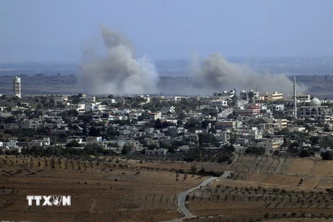 Khói bốc lên từ làng Jubata al-Khashab của Syria sau một vụ không kích của trực thăng quân sự. (Nguồn: AFP/TTXVN)