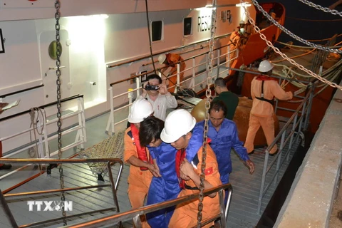 Một thuyền viên sức khỏe còn yếu được lực lượng cứu nạn tàu SAR 412 đưa lên bờ. (Ảnh: Đinh Văn Nhiều/TTXVN)