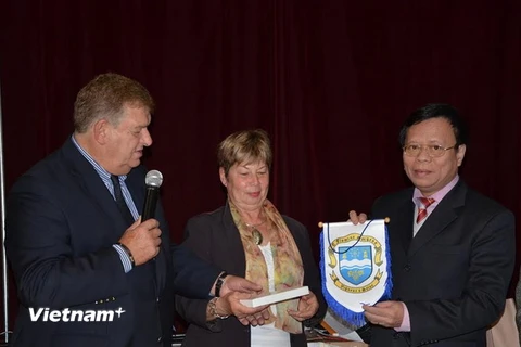 Thị trưởng thành phố Vigneux-sur-Seine, ông Serge Poinsot, trao quà cho Công sứ Đặng Giang tại buổi lễ. (Ảnh: Bích Hà/Vietnam+)