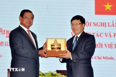 Phó Thủ tướng Phạm Bình Minh và Phó Thủ tướng Campuchia Samdech Krolahom Sar Kheng trao tặng quà lưu niệm. (Ảnh: Thanh Vũ/TTXVN)