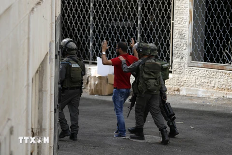 Nhân viên an ninh Israel bắt giữ một người Palestine sau cuộc đụng độ tại làng al-Ram, nằm giữa Jerusalem và Ramallah, Bờ Tây. (Nguồn: AFP/TTXVN)