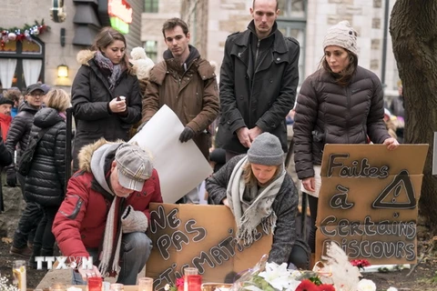 Người dân Canada thắp nến tưởng niệm các nạn nhân vụ tấn công khủng bố ở Pháp bên ngoài Lãnh sự quán Pháp ở thành phố Quebec. (Nguồn: AFP/TTXVN)