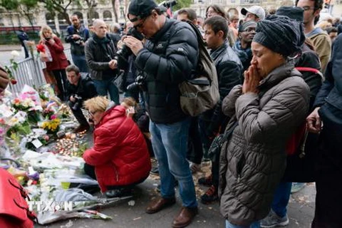 Người dân đặt hoa thắp nến gần Nhà hát Bataclan ở thủ đô Paris, một trong những nơi xảy ra các vụ tấn công khủng bố. (Nguồn: Kyodo/TTXVN)