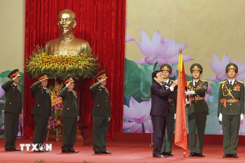Chủ tịch nước Trương Tấn Sang gắn Danh hiệu Anh hùng Lao động lên lá cờ truyền thống của Ngân hàng Thương mại Cổ phần Quân đội. (Ảnh: Nguyễn Khang/TTXVN)