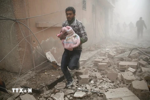 Người dân Syria sơ tán khỏi khu vực giao tranh ở Douma. (Nguồn: AFP/TTXVN)