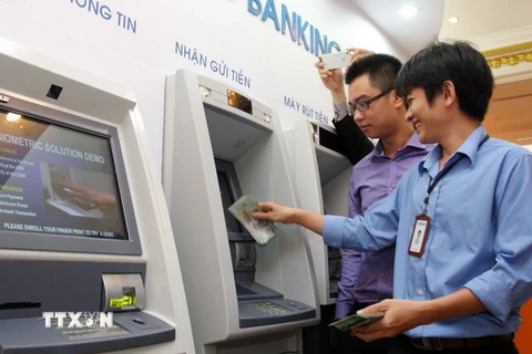 Khách hàng rút tiền tại một điểm giao dịch ATM trên địa bàn Hà Nội. (Ảnh: Trần Việt/TTXVN)
