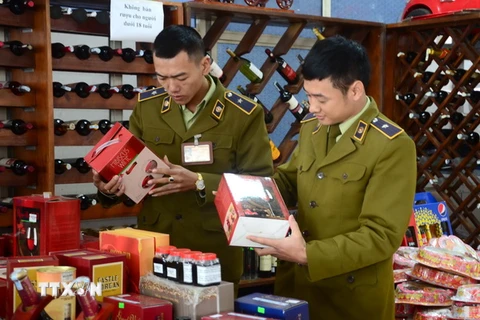 Lực lượng quản lý thị trường tỉnh Điện Biên kiểm tra một cửa hàng kinh doanh rượu, bánh kẹo Tết. (Ảnh: Xuân Tư/TTXVN)
