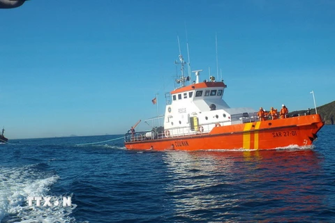 Tàu SAR27-01 đưa tàu bị nạn cùng hai ngư dân vào bờ. (Ảnh: Tiên Minh/TTXVN)