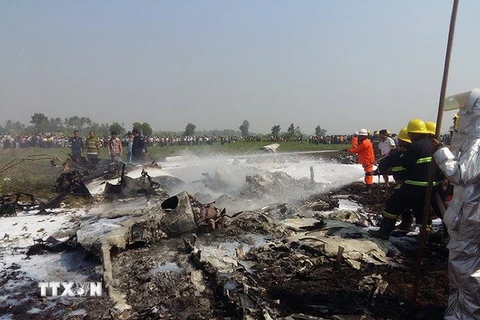 Lính cứu hỏa dập lửa bùng lên từ xác máy bay bị rơi gần Naypyidaw. (Nguồn: AFP/TTXVN)