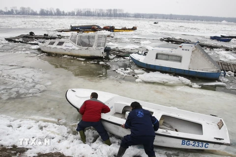 Người dân cố gắng cứu chiếc tàu bị hỏng do băng nổi trên sông Danube ở Belgrade. (Nguồn: THX/TTXVN)