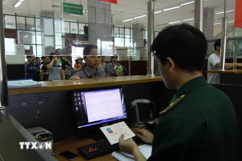 Bộ đội Biên phòng Cửa khẩu quốc tế Lào Cai làm thủ tục cho khách xuất cảnh. (Ảnh: Vũ Sinh/TTXVN)
