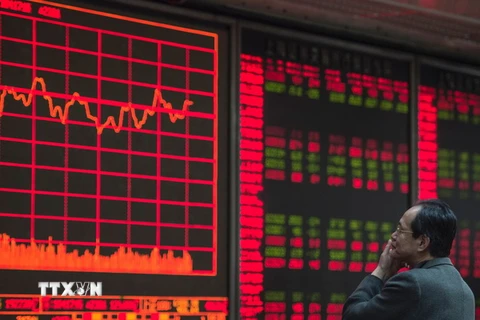 Nhà đầu tư theo dõi các chỉ số chứng khoán tại thủ đô Bắc Kinh. (Nguồn: AFP/TTXVN)