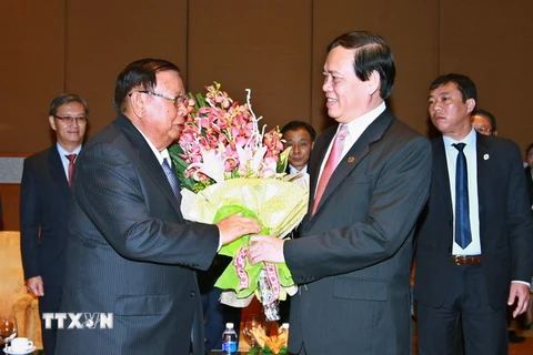 Chủ tịch Hội Hữu nghị Việt Nam-Lào Vũ Trọng Kim tặng hoa Tổng Bí thư, Chủ tịch nước Lào. (Ảnh: Doãn Tấn/TTXVN)