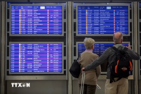 Hành khách xem bảng thông báo hủy các chuyến bay tại sân bay ở Frankfurt. (Nguồn: AFP/TTXVN)